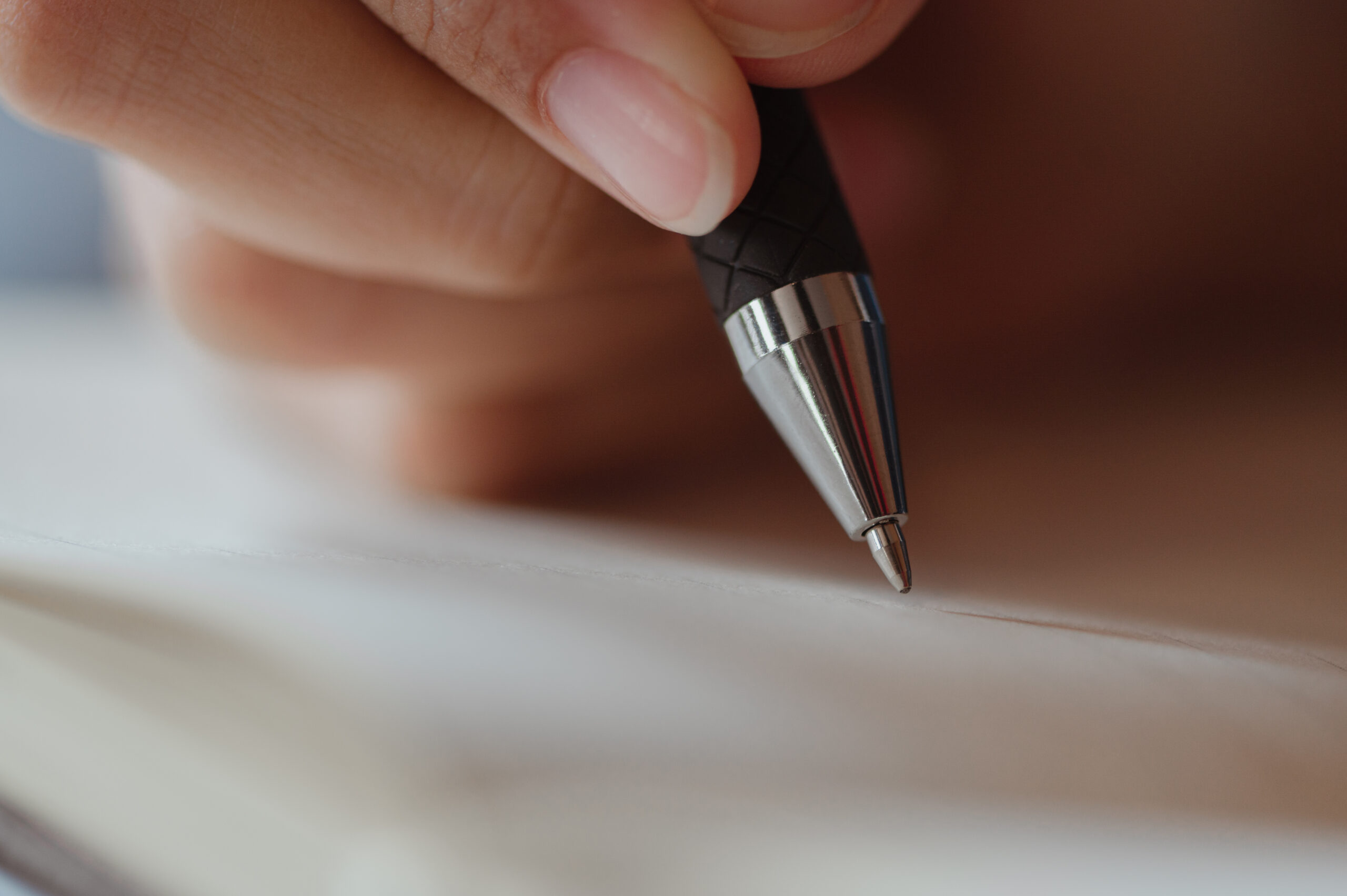 Female hand close-up writes with a pen in a blank notebook. Business woman, writer, personal blog Concepts.